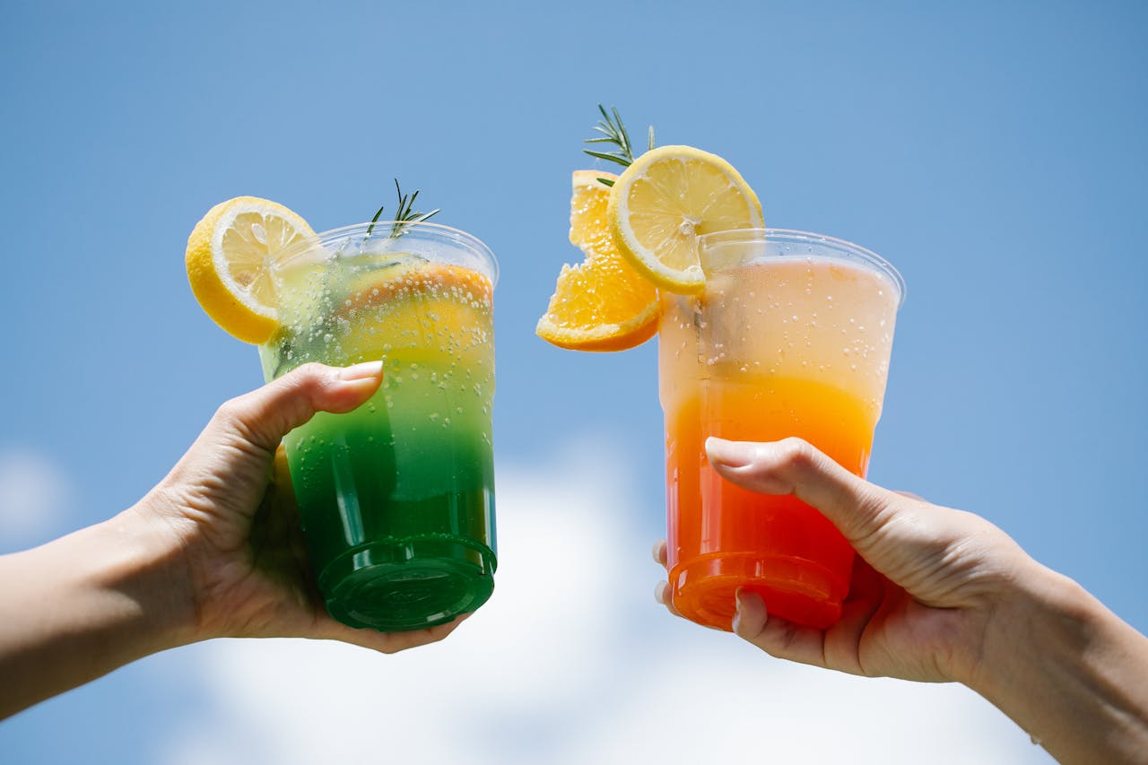 Refreshing citrus drinks against a clear blue sky, perfect for summer.